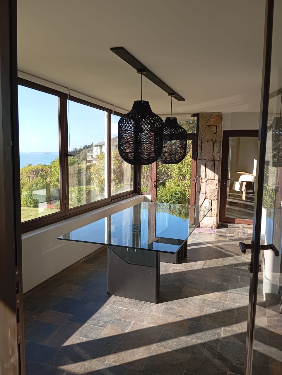 Comedor con ventanales y vista al mar en una casa construida por Pilpilén